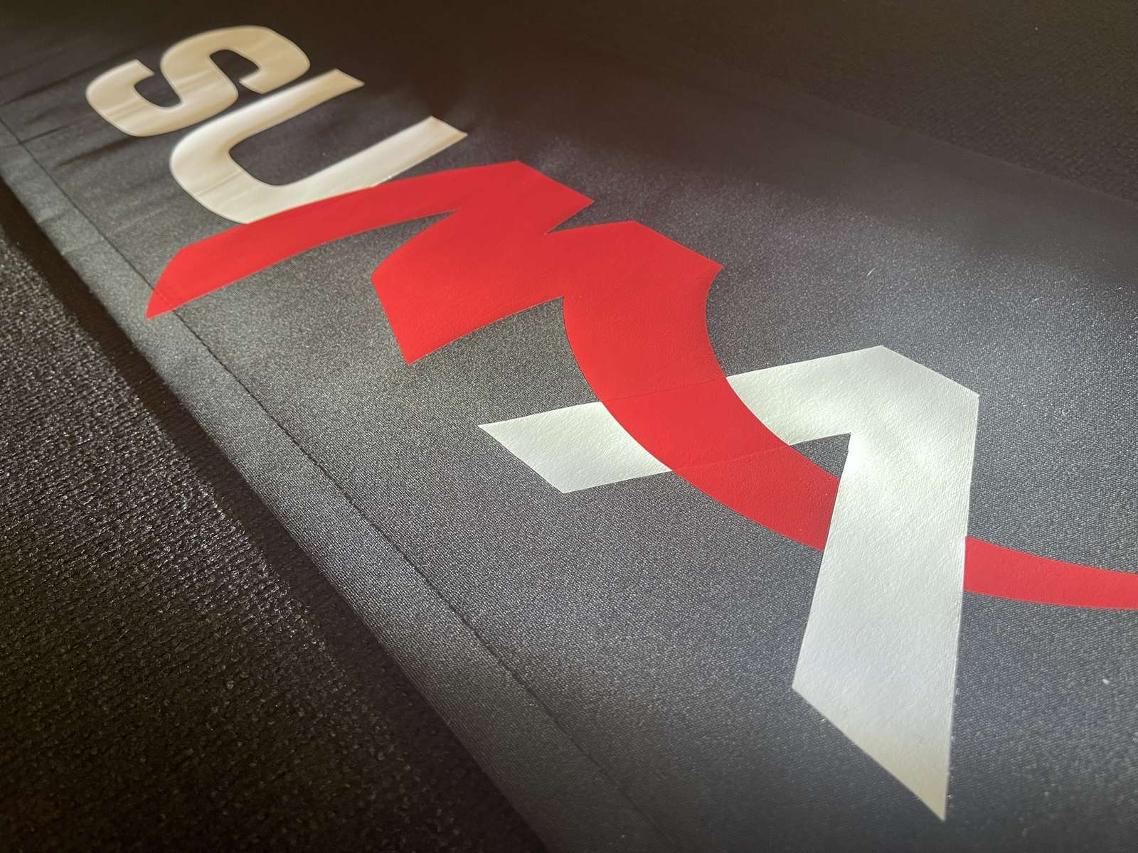 Marquage sur lambrequin : logo rouge et blanc floqué sur toile anthracite