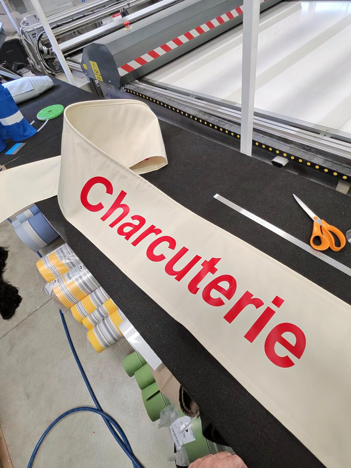 Lambrequin de store banne personnalisé avec marquage flex rouge pour une charcuterie